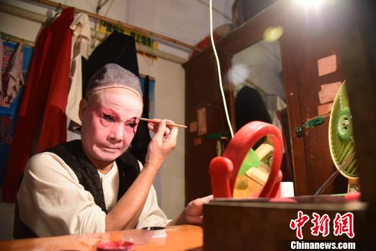 一面小镜子、一个小电扇和几盒化妆颜料就是桂剧演员的化妆室。　王以照摄