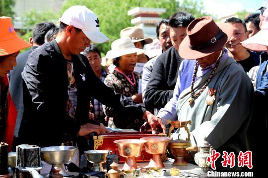 在中国文化和自然遗产日前夕，西藏山南市琼结县民族优秀服装、工艺品、舞蹈、音乐和酒文化等非遗项目集体亮相，为当地民众呈现文化饕餮盛宴。图为多吉铁艺合作社的产品得到了现场观众的欢迎。　伦珠泽仁摄