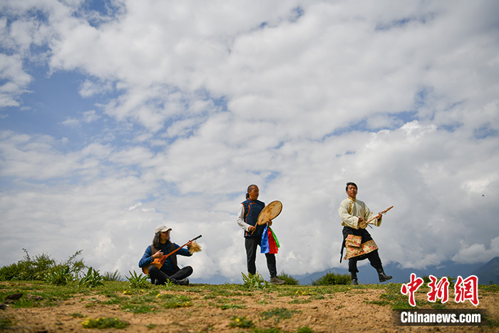 图为7月10日，藏族音乐人热西·才让旦（中）伴着音乐敲响神鼓。 <a target='_blank' href='/'>中新社</a>记者刘冉阳摄