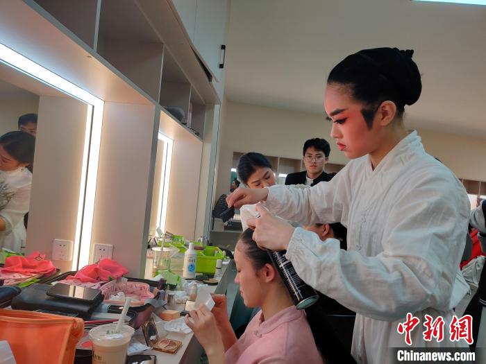 厦门艺术学校歌仔戏班学生杨婉婷(右一)正在给同学整理妆发。　叶秋云摄